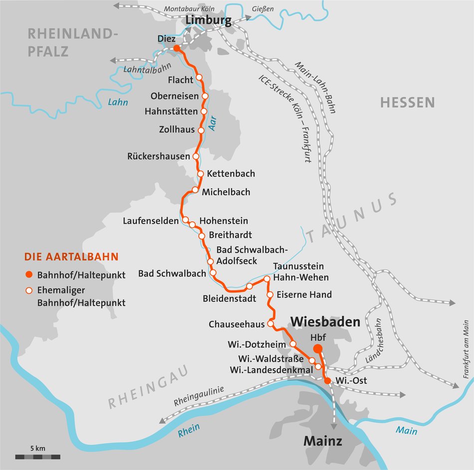 Eine graue Karte zeigt den Streckenverlauf der Aartalbahn von Wiesbaden nach Diez. Der Streckenverlauf ist orange hervorgehoben und zeigt auch ehemalige Bahnhöfe an.