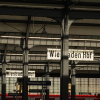 Bild zeigt durch einen Torbogen einen seitlichen Blick auf die Gleise im Wiesbadener Hauptbahnhof