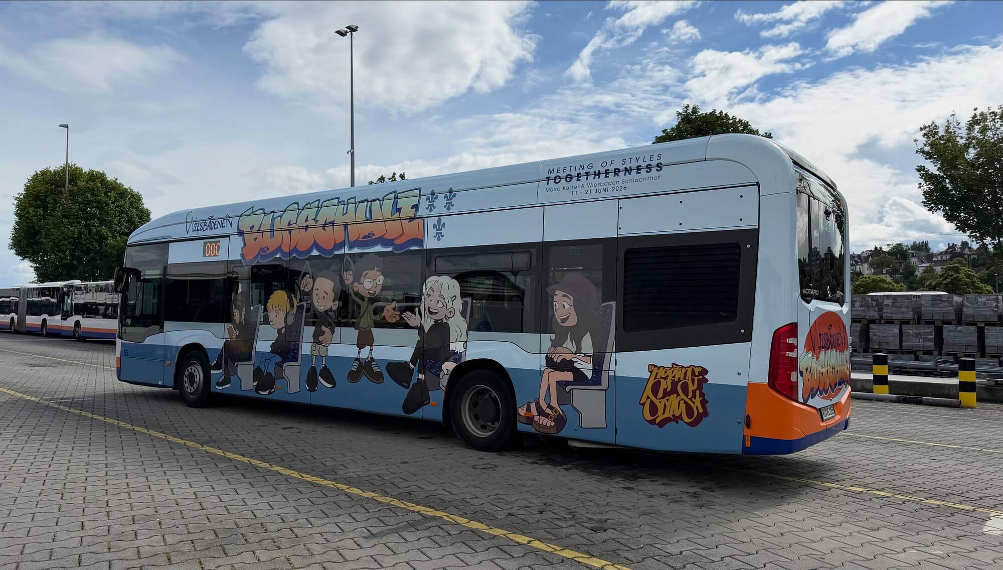 ESWE-Verkehr-Bus mit bunter Busschule-Beklebung und Comicfiguren auf einem Betriebshof.