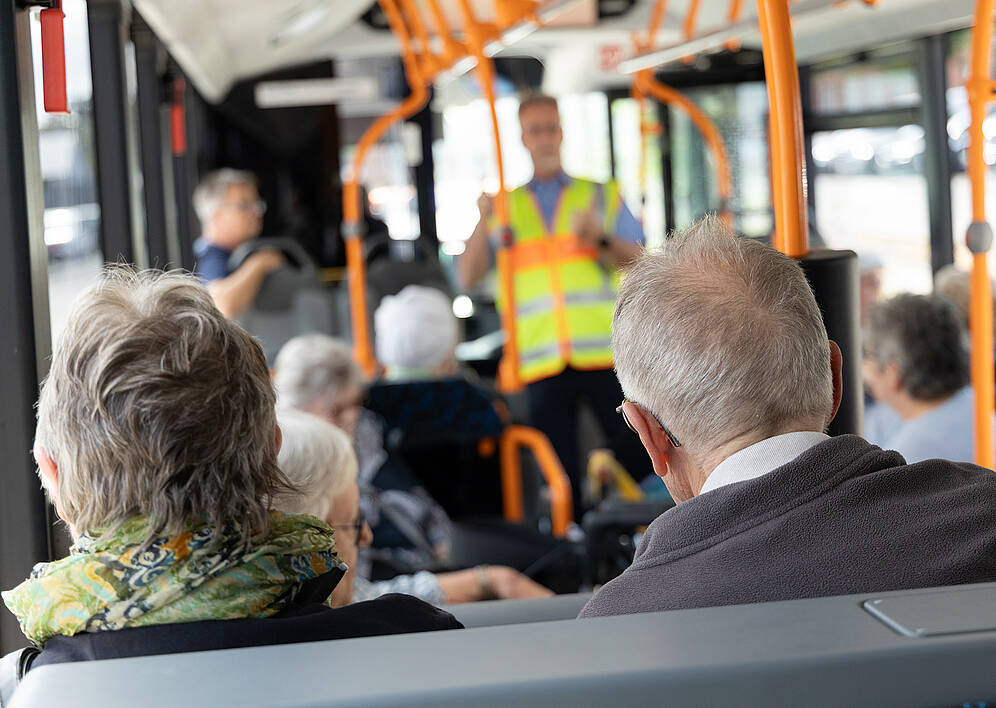 zeigt Senioren im Bus